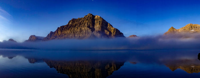 Panoramic view of lake and rocks against blue sky