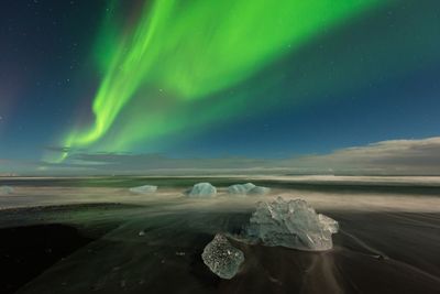 View of northern lights over glacier at night