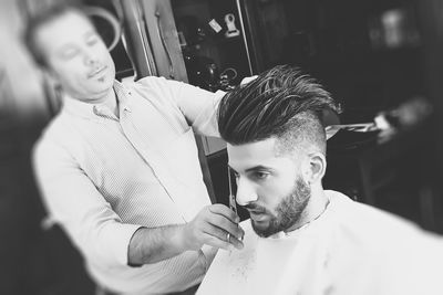 Man having haircut in saloon