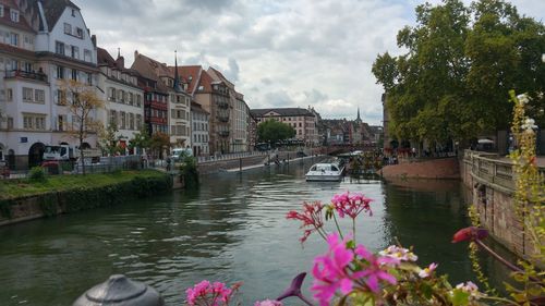 Scenic view of river by buildings against sky