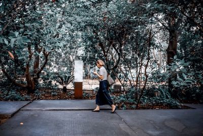 Woman standing on tree trunk