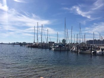 Sailboats moored on sea against sky