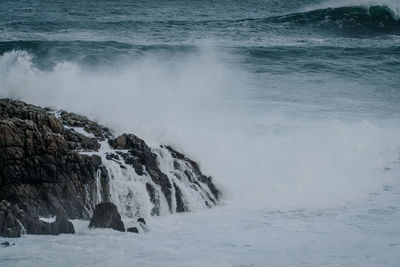 Scenic view of waves breaking on rocks