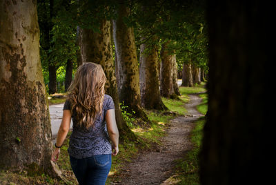 Rear view of woman walking on footpath