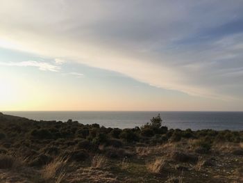 Scenic view of calm sea against cloudy sky