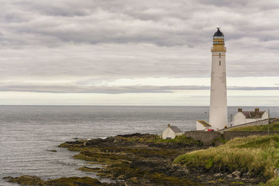 Lighthouse by sea against cloudy sky at montrose