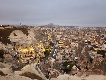 Cave houses and volcanic landscape of cappadocian town goreme and uchisar castle in early morning.