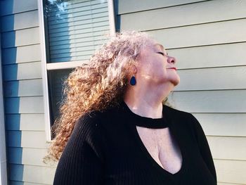 Young woman standing against built structure