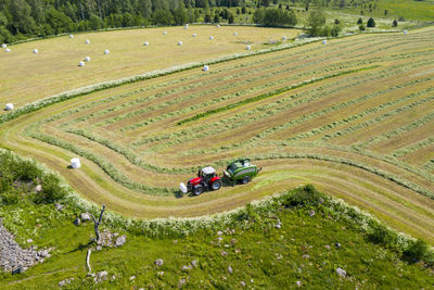 Tractor collecting hay on field