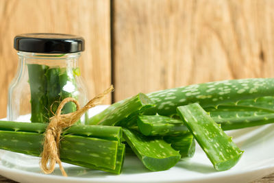 Sliced aloe vera plant with jar on plate