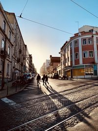 People walking on street in city in the late afternoon 