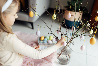 High angle view of girl decorating easter eggs