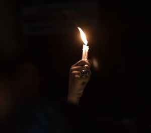 Close-up of lit candle in darkroom