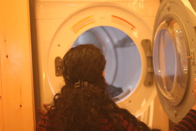 Rear view of woman opening laundromat door