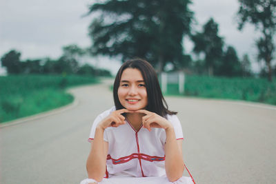 Portrait of a smiling young woman holding camera