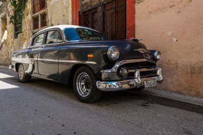 Vintage car on street against buildings in city