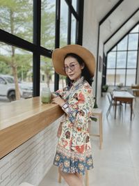 Portrait of smiling young woman standing in corridor