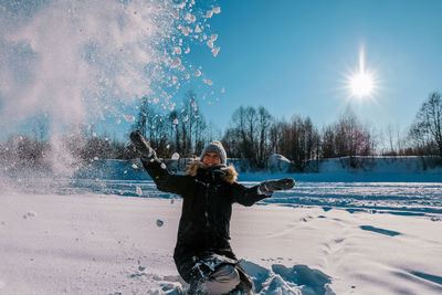 Women with arms outstretched in snow during winter