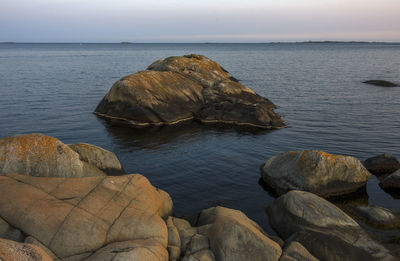 Rocks in sea against sky