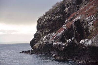 Scenic view of cliff by sea