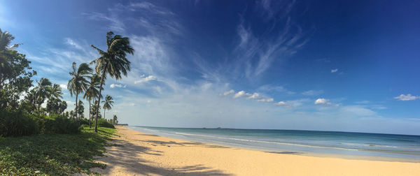 Scenic view of sea against blue sky on sunny day