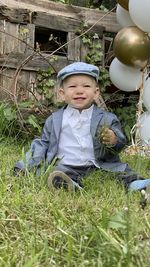 Portrait of cute boy sitting on land