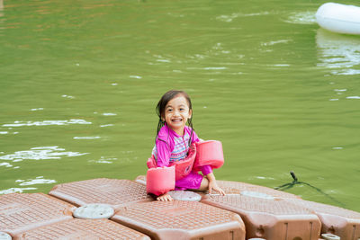 Portrait of a smiling girl sitting in water