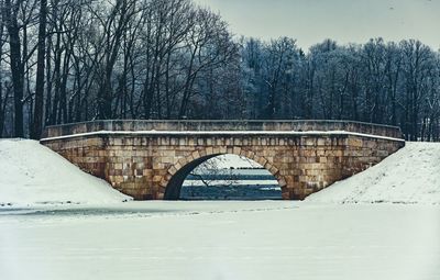 Snow covered arch bridge against sky during winter