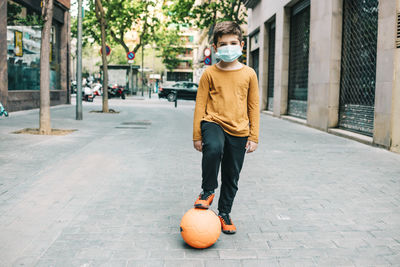 Full length portrait of boy on street in city