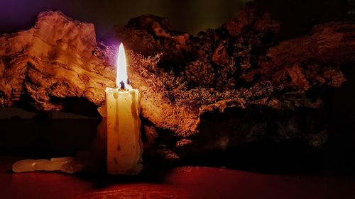 Close-up of lit candle in darkroom