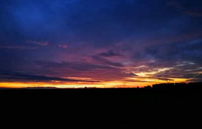 Silhouette landscape against dramatic sky during sunset