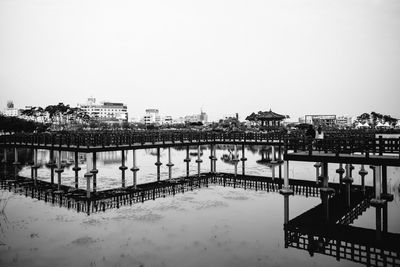 Bridge over river in city against clear sky