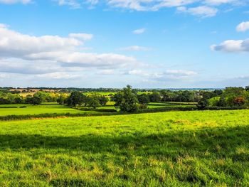 Scenic view of field against cloudy sky