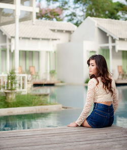 Young woman looking down while sitting outdoors