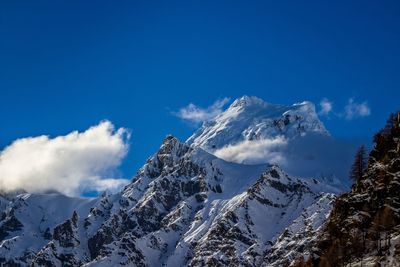 Scenic view of snowcapped mountains against blue sky