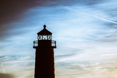 Low angle view of silhouette lighthouse against sky