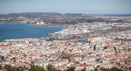 High angle view of townscape by sea against sky