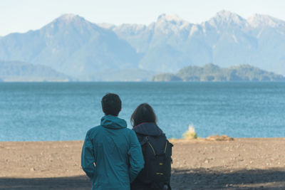 Rear view of man and woman looking at sea