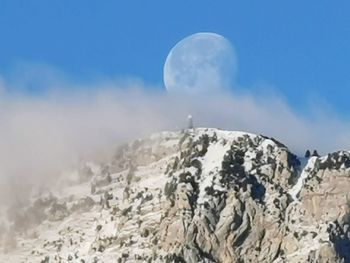 Low angle view of snowcapped mountains against sky