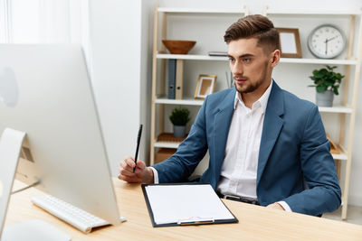 Businessman looking at desktop pc at office