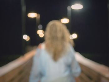 Rear view of woman on illuminated city at night