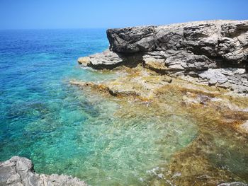 Rock formation in sea against sky