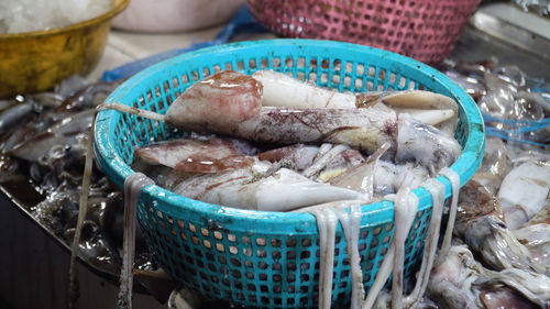 Fresh squids in a plastic basket for sale at a seafood market in the philippines. 