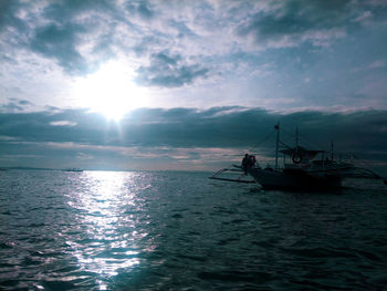 Silhouette boat in sea against sky during sunset