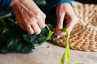 Midsection of person preparing christmas decoration on table