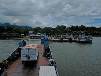 Boats moored on river against sky