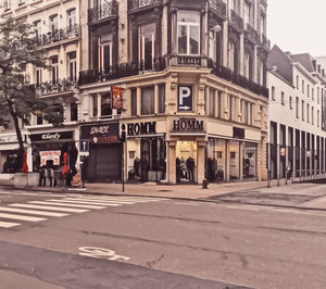 People walking on road against buildings in city