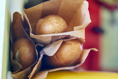 Close-up of breads in paper bags on table