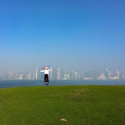 Boy jumping against clear blue sky