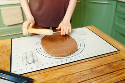 Midsection of woman holding food on table